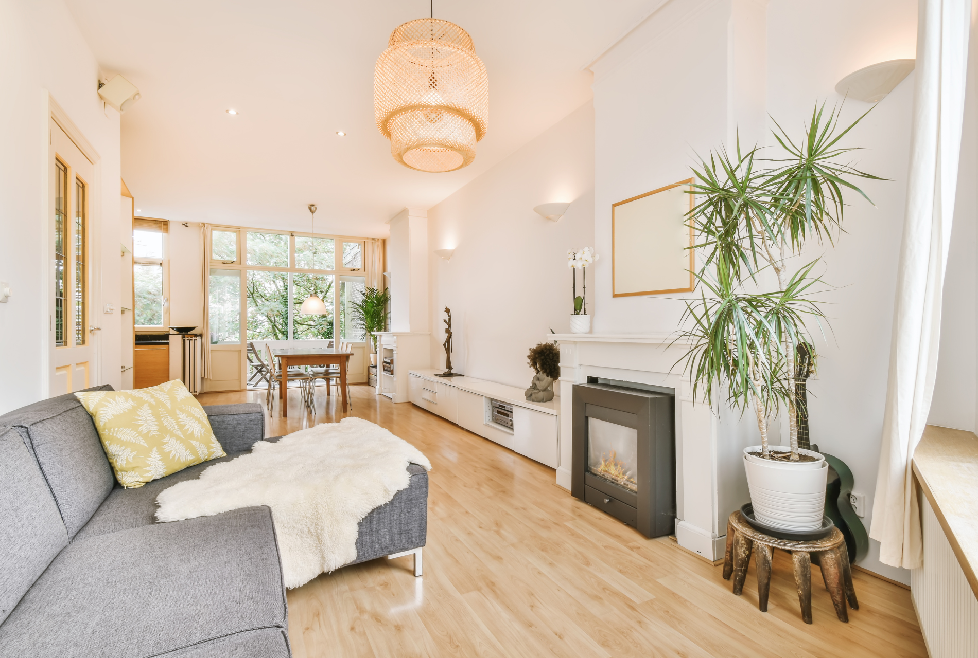 A living room with a couch , fireplace , and plant.