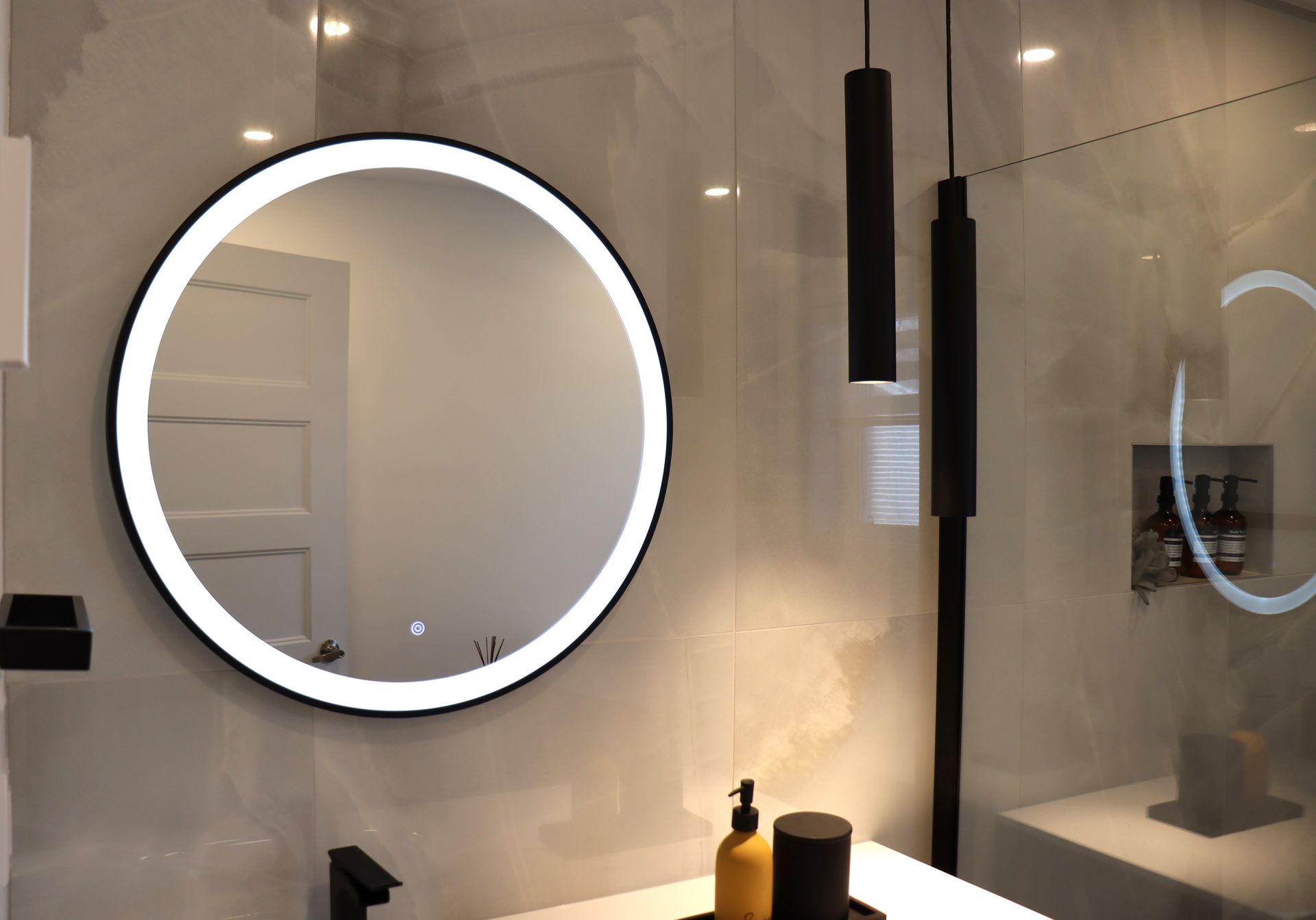 Une salle de bain avec un miroir rond et un lavabo.