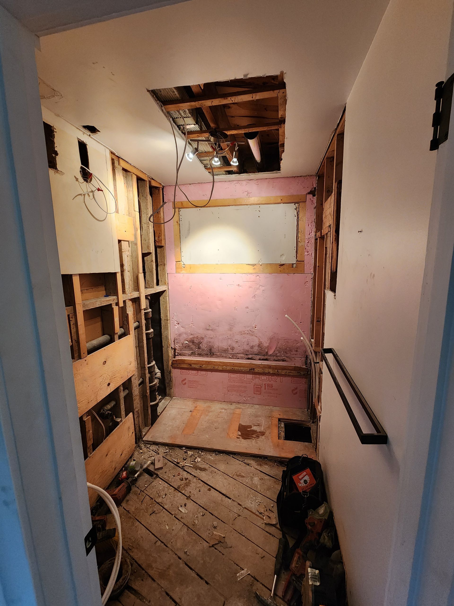 Une salle de bain en construction avec un trou au plafond.