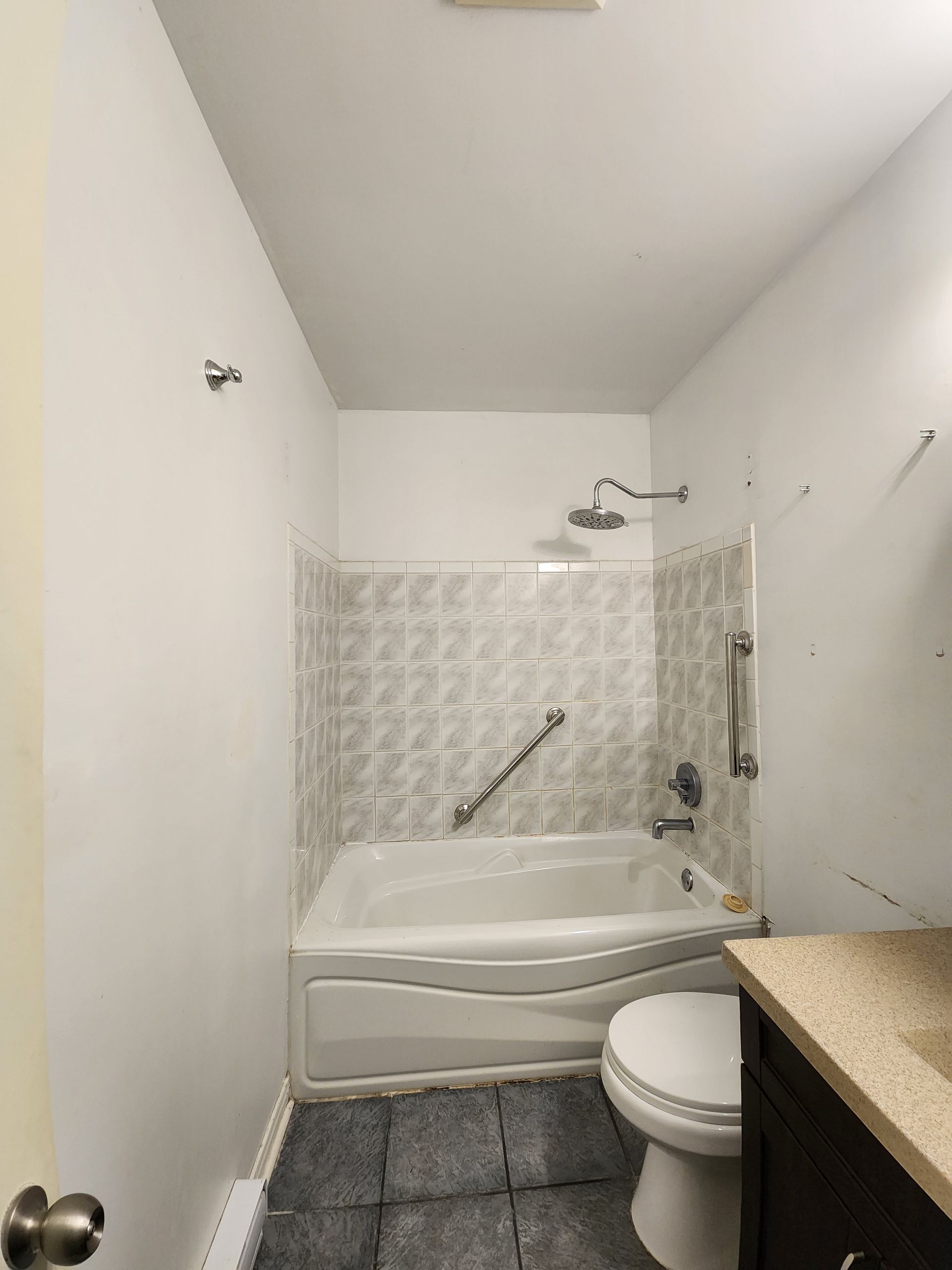 Une salle de bain avec baignoire , WC , lavabo et douche.