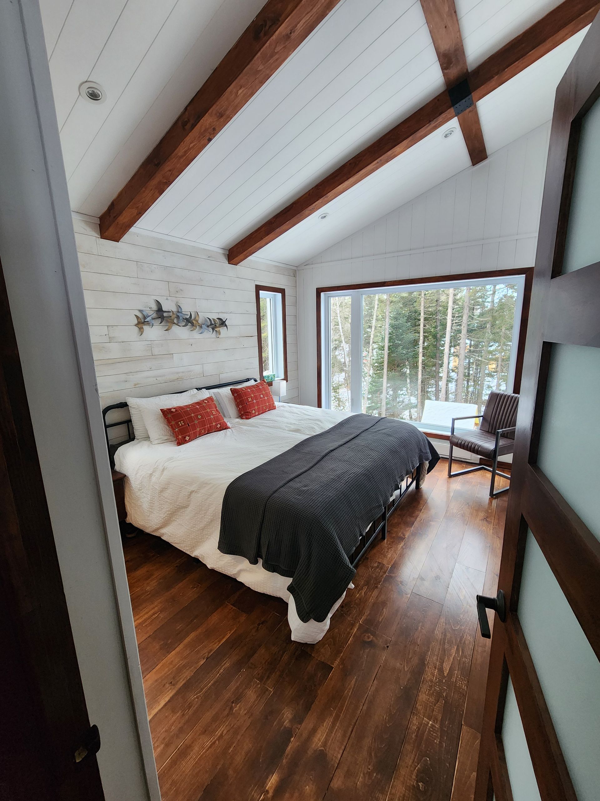 Une chambre avec un grand lit et une porte coulissante vitrée.