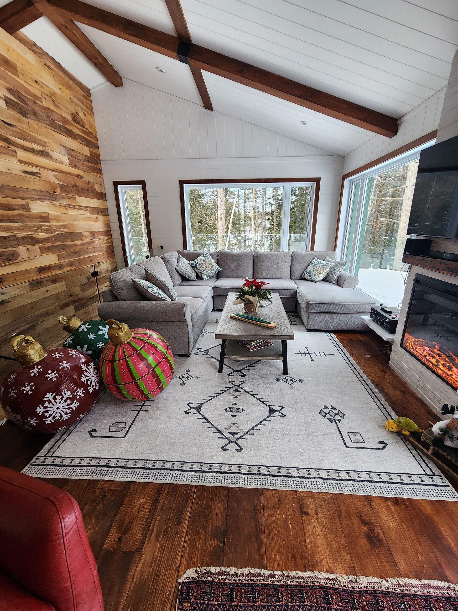 Un salon avec un canapé sectionnel, une table basse, un foyer et des décorations de Noël.