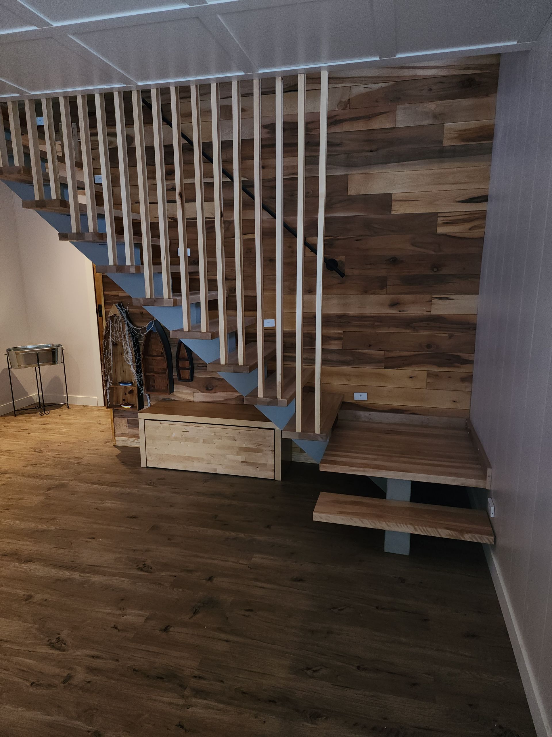 Un escalier en bois avec une rampe bleue dans une pièce