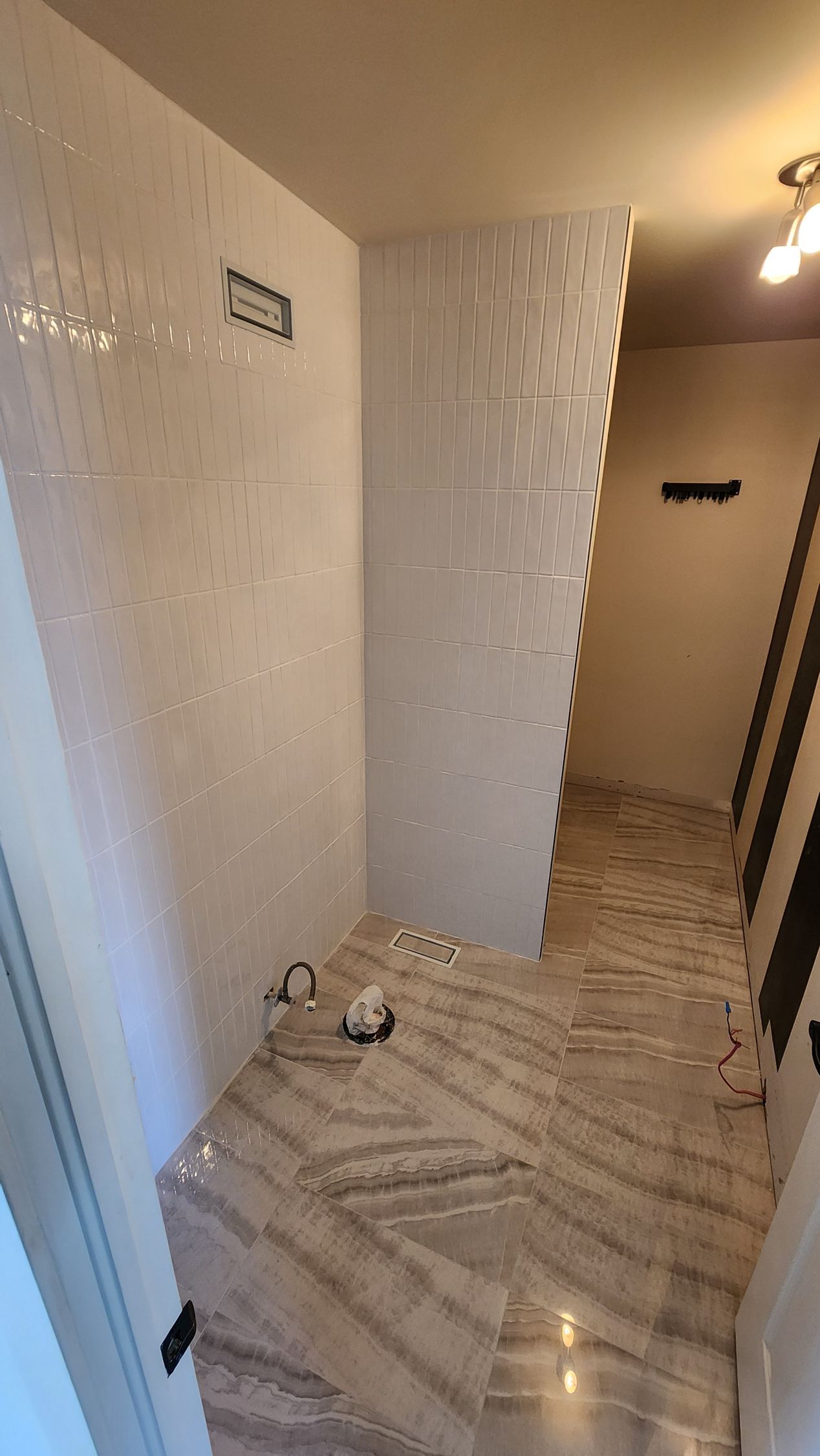 Une salle de bain avec douche à l'italienne et sol en marbre.