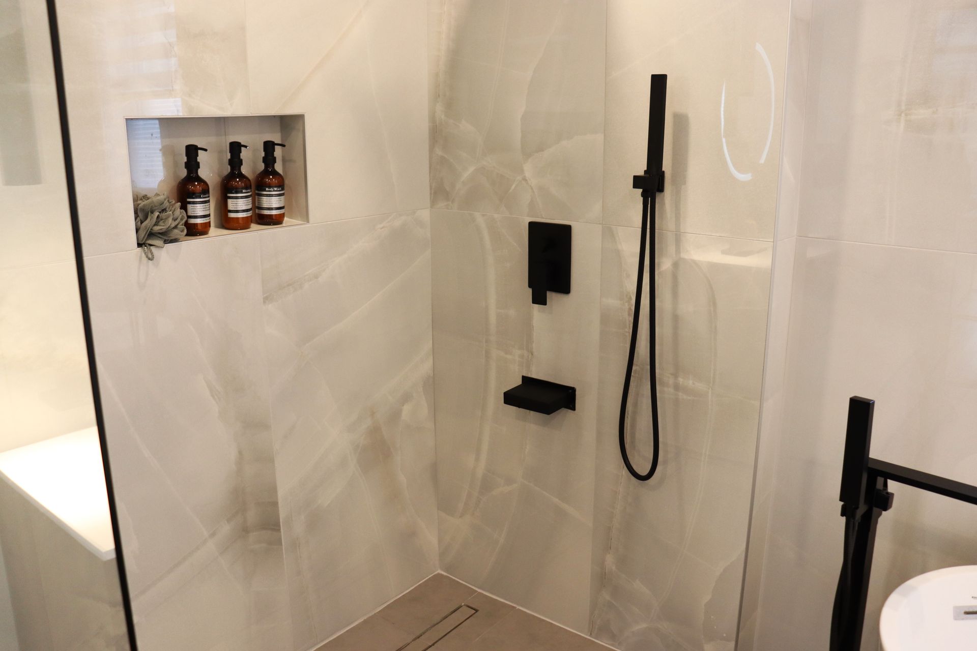 Une salle d'eau avec douche à l'italienne et lavabo.