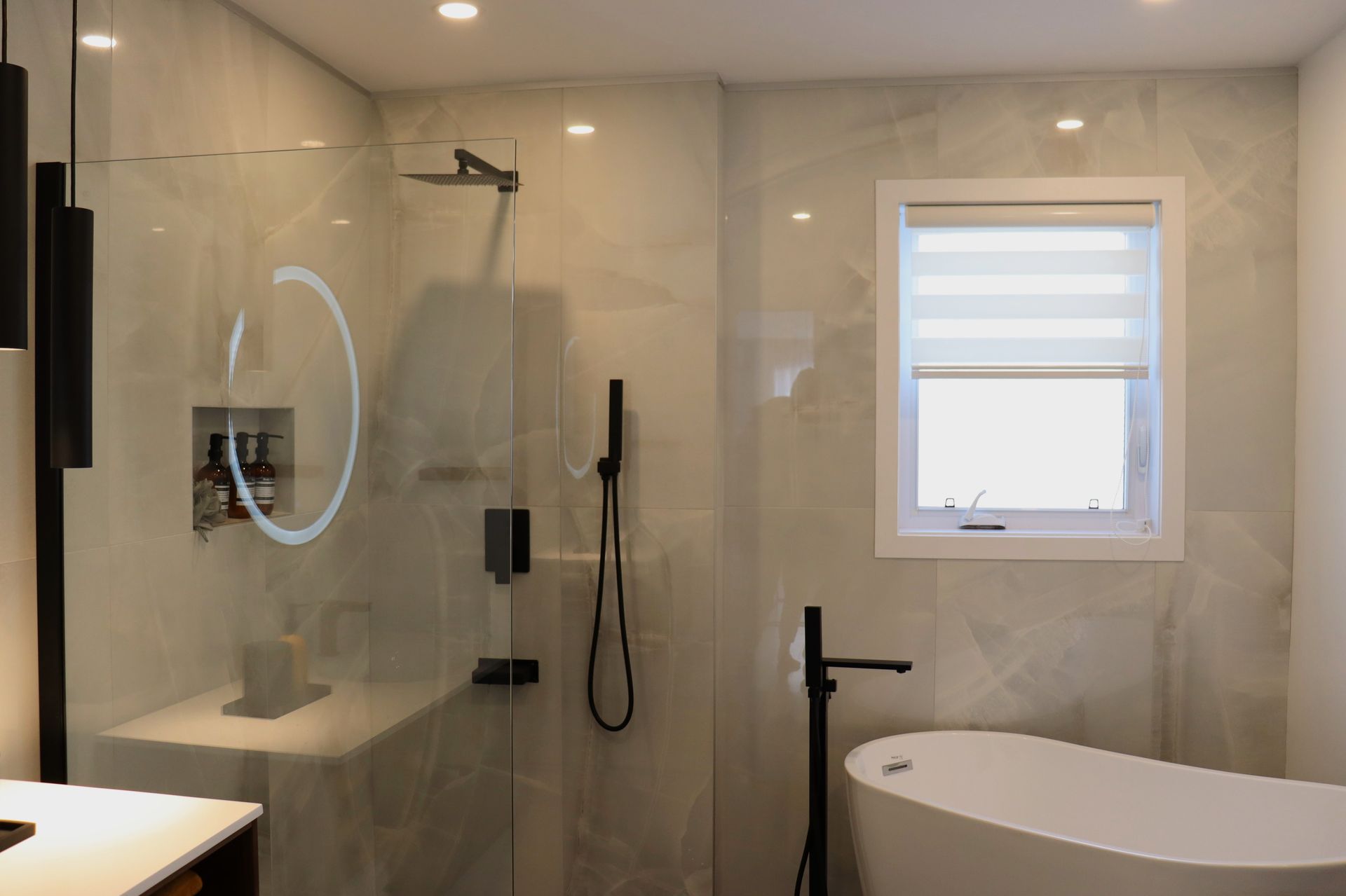 Une salle de bain avec baignoire , douche , miroir et fenêtre.