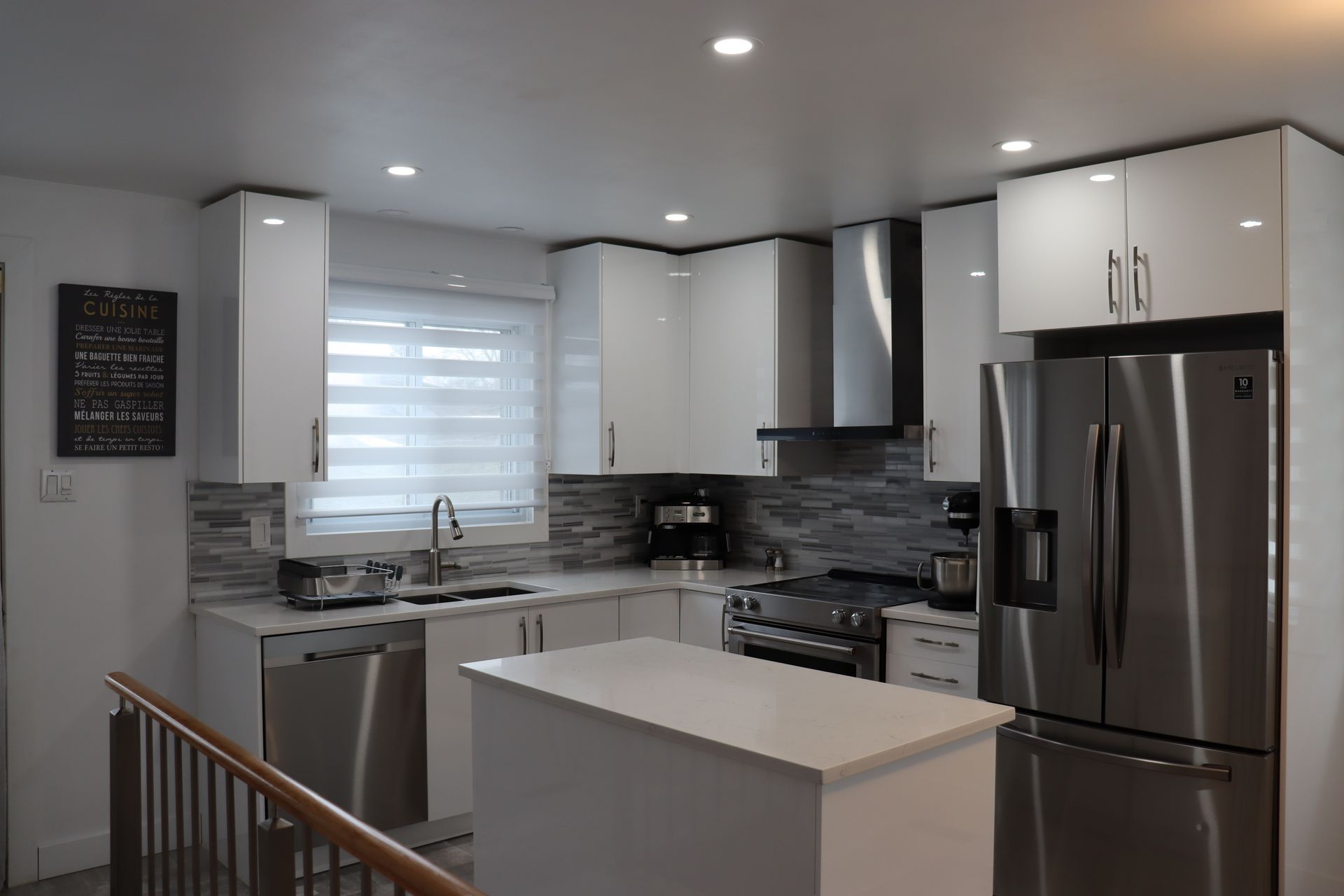 Une cuisine avec des appareils électroménagers en acier inoxydable et des armoires blanches