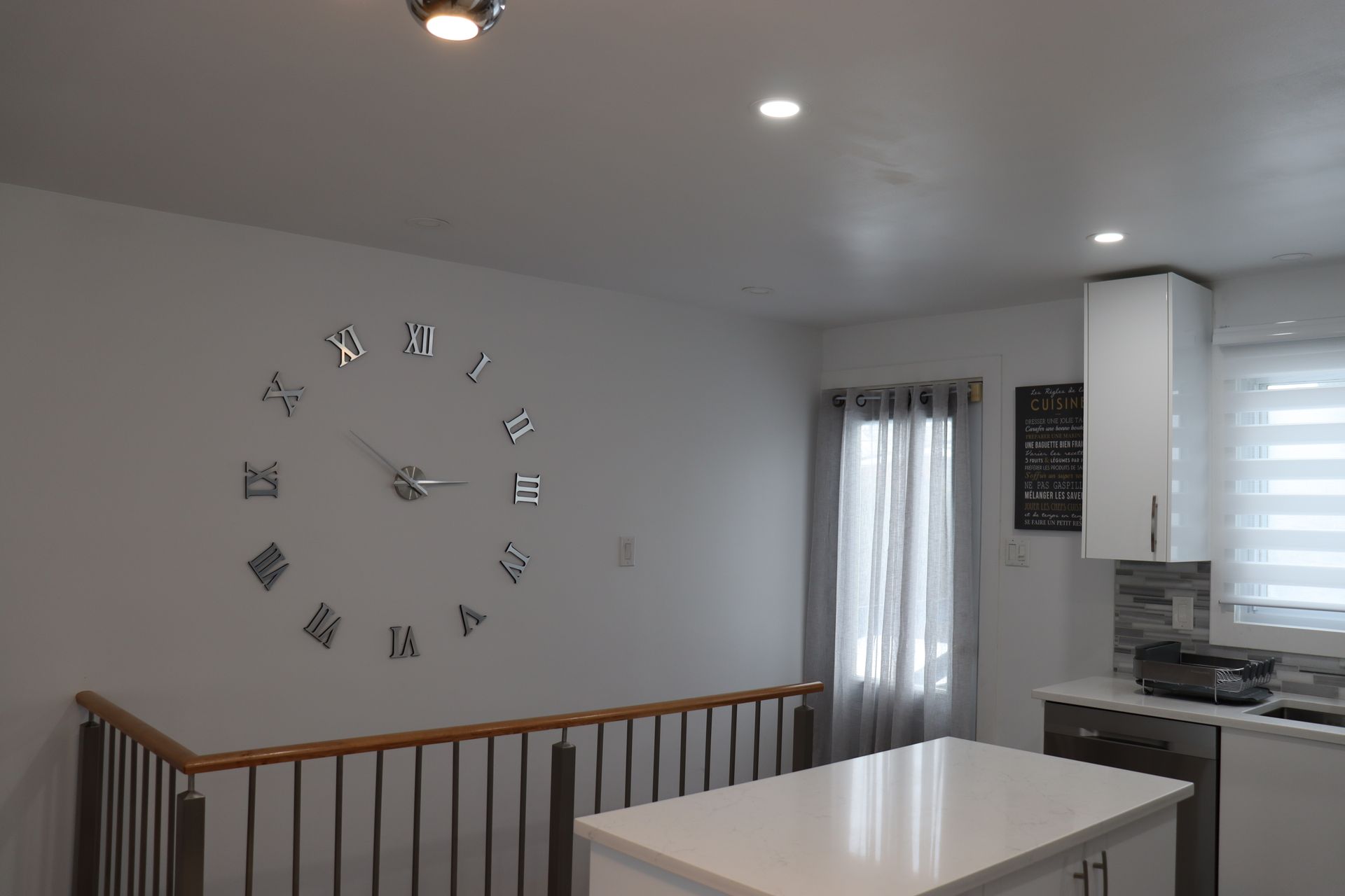 Une cuisine avec une grande horloge au mur.