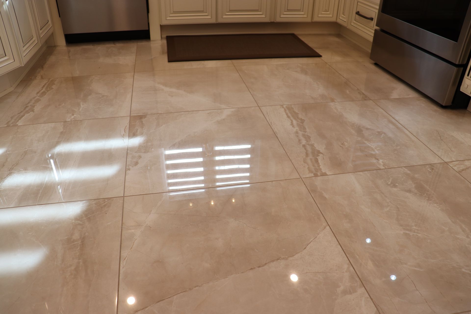 Une cuisine avec carrelage au sol et poêle.