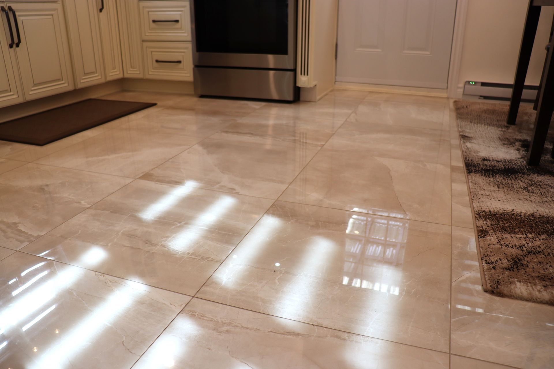 Une cuisine avec carrelage au sol et poêle.