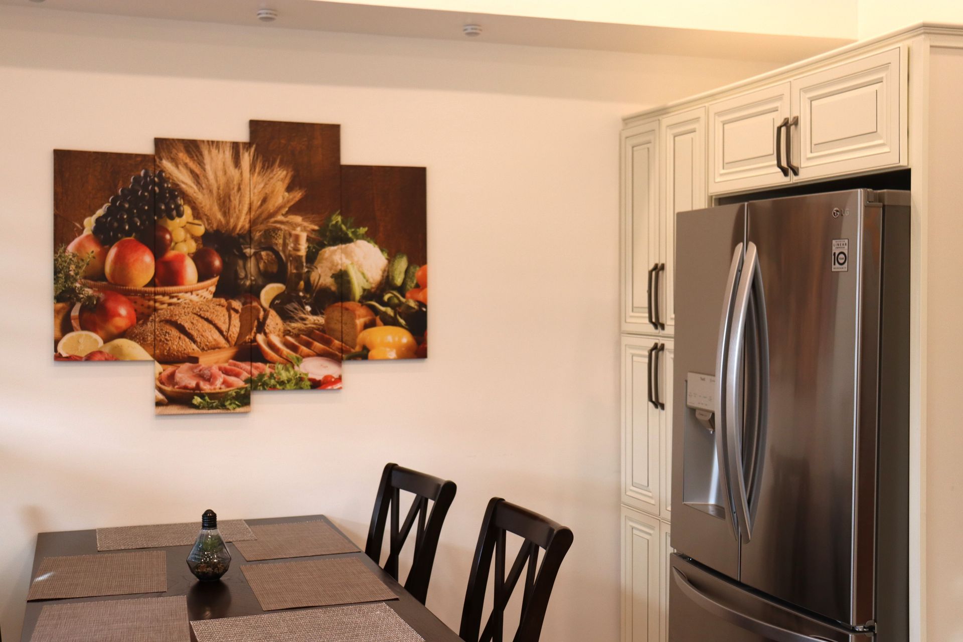 Une cuisine avec une table et des chaises et un réfrigérateur