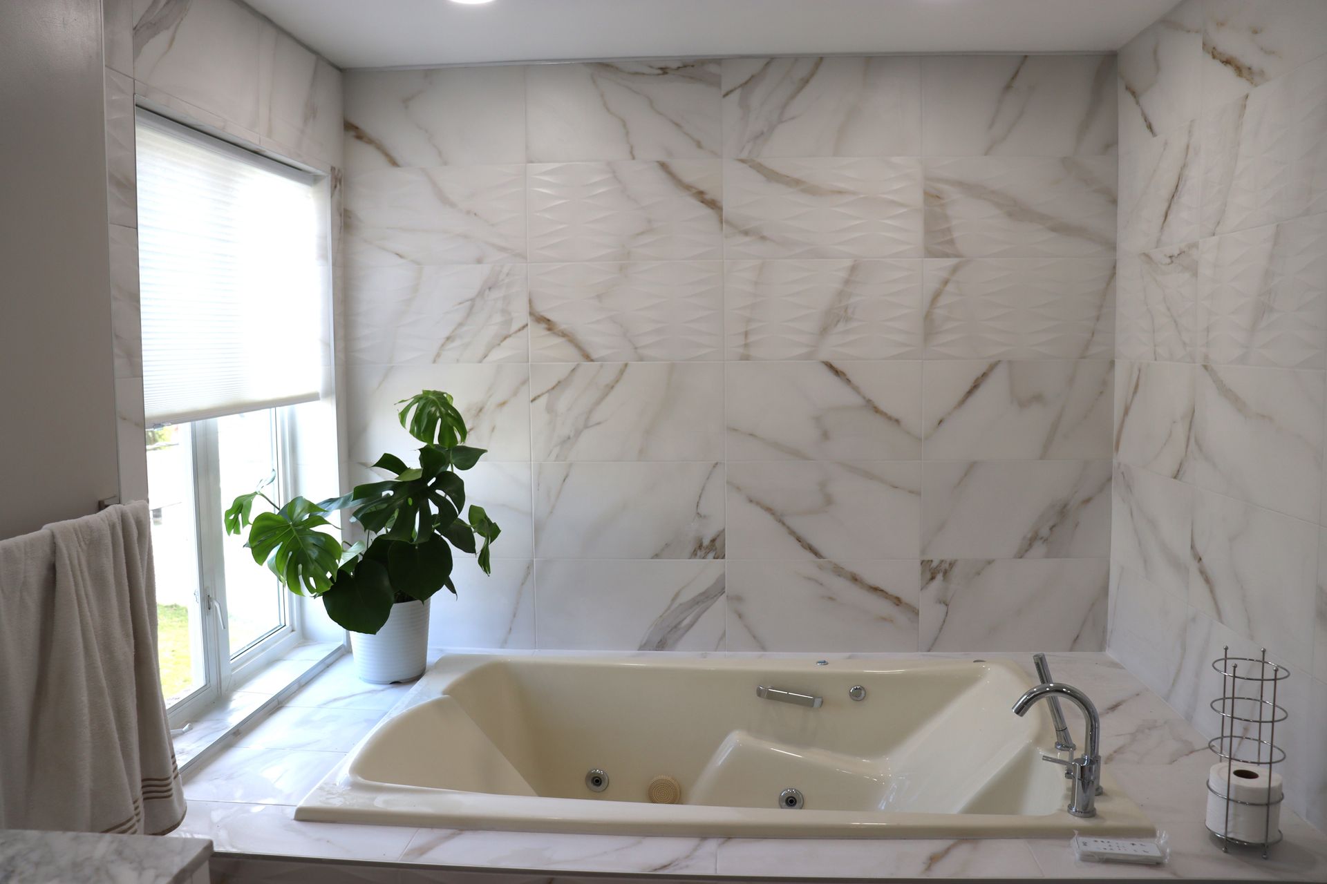 Une salle de bain avec une baignoire jacuzzi et une fenêtre