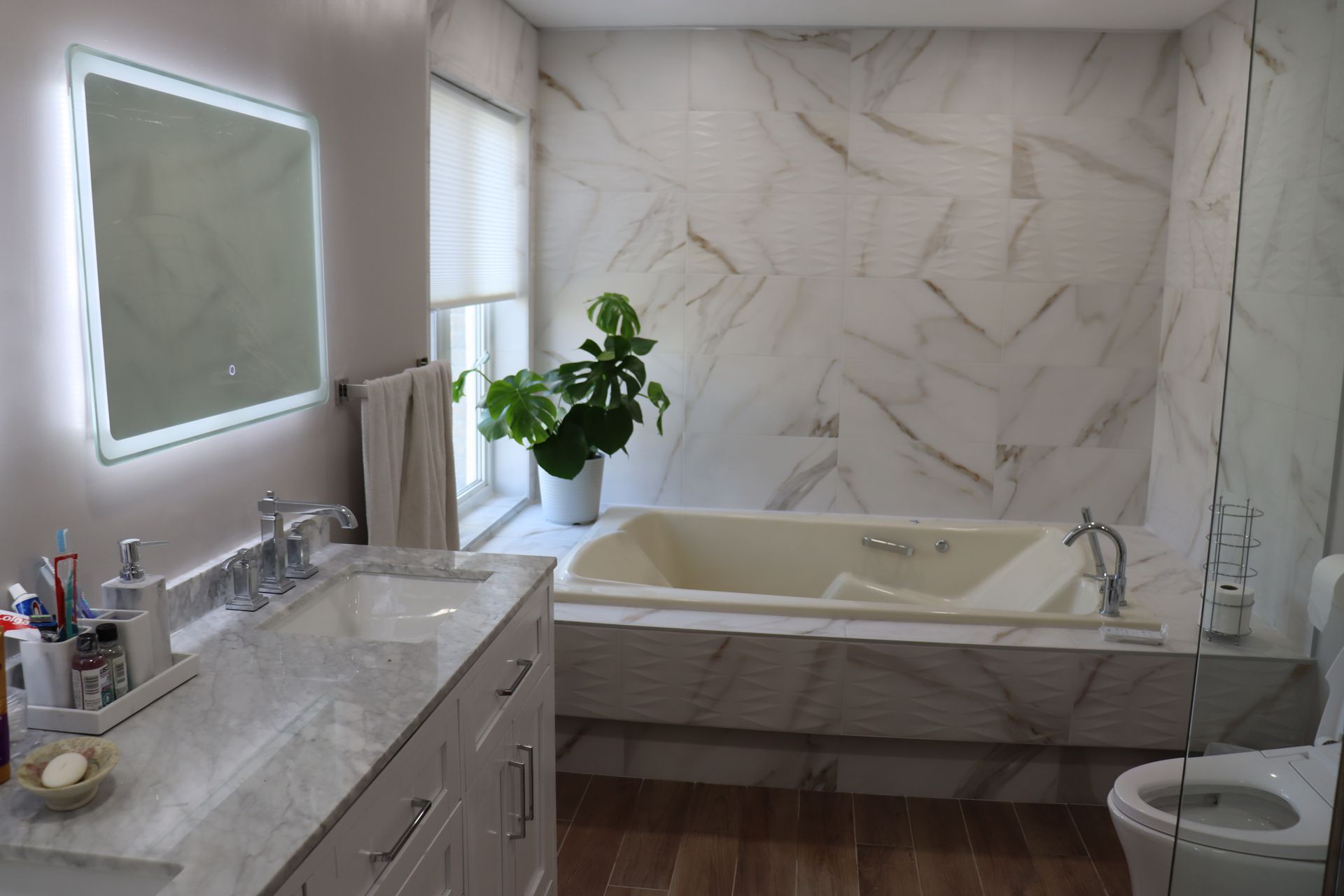 Une salle de bain avec baignoire , lavabo , toilettes et miroir.