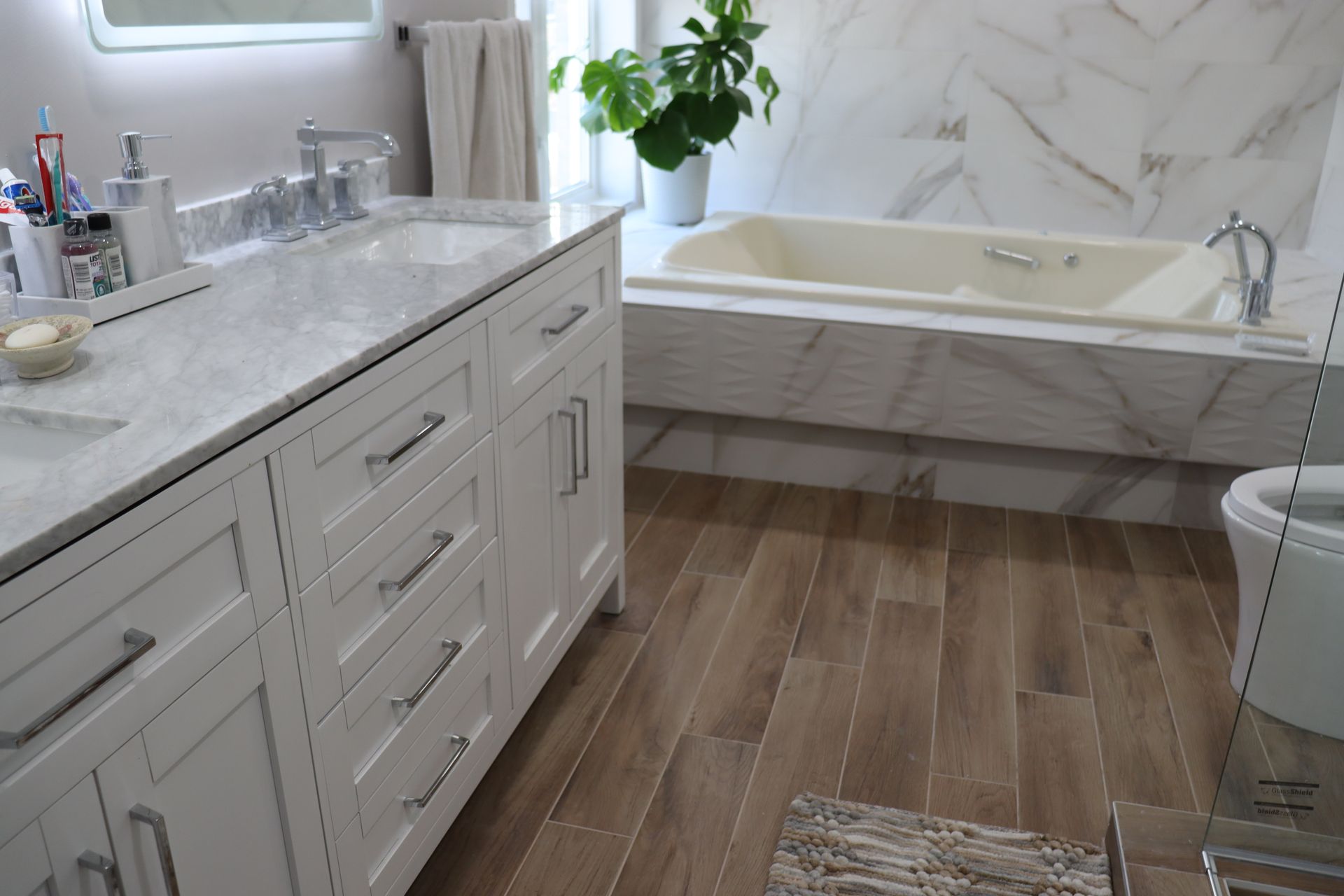 Une salle de bain avec baignoire , lavabo , toilettes et miroir.