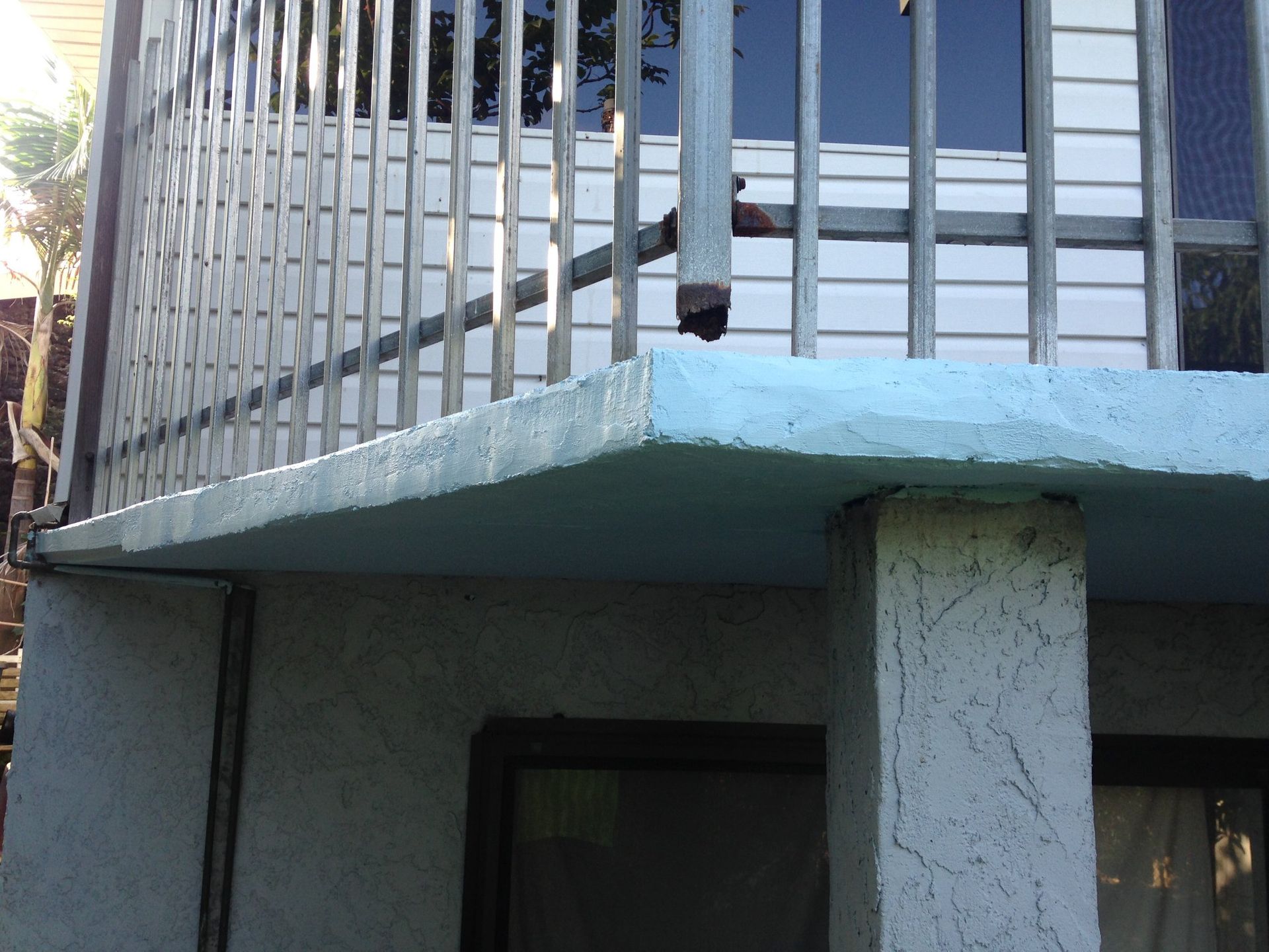 A balcony with a metal railing on the side of a building.