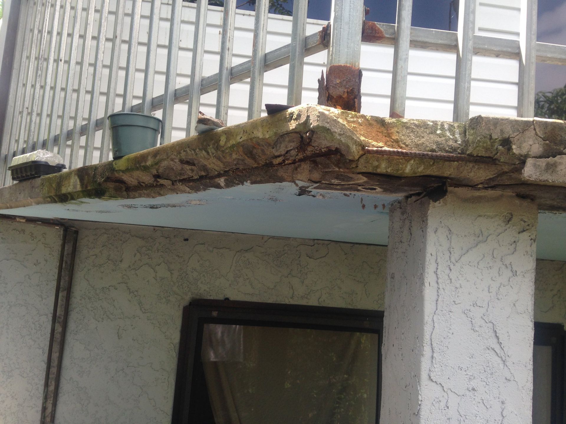 A building with a balcony and a broken roof