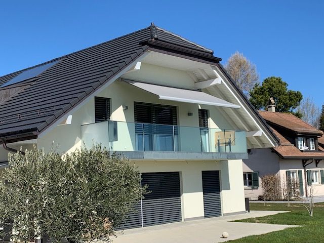 Une maison avec un balcon et un toit avec des panneaux solaires
