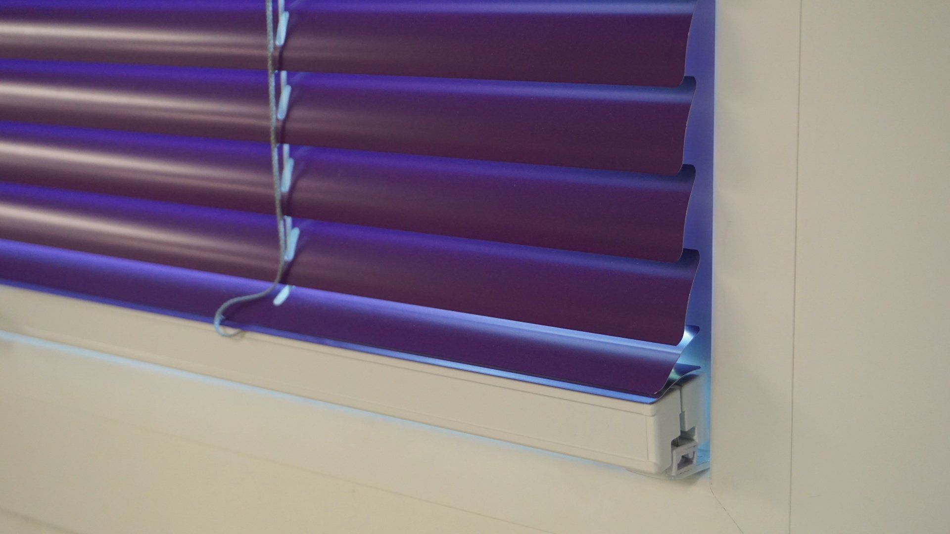 Un gros plan d'un store violet sur une fenêtre.