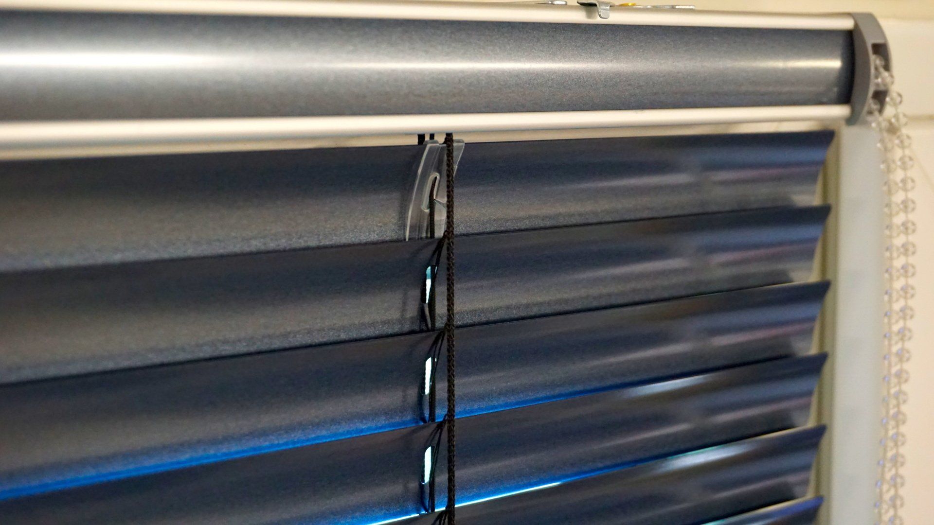 Un gros plan d'un store bleu sur une fenêtre.