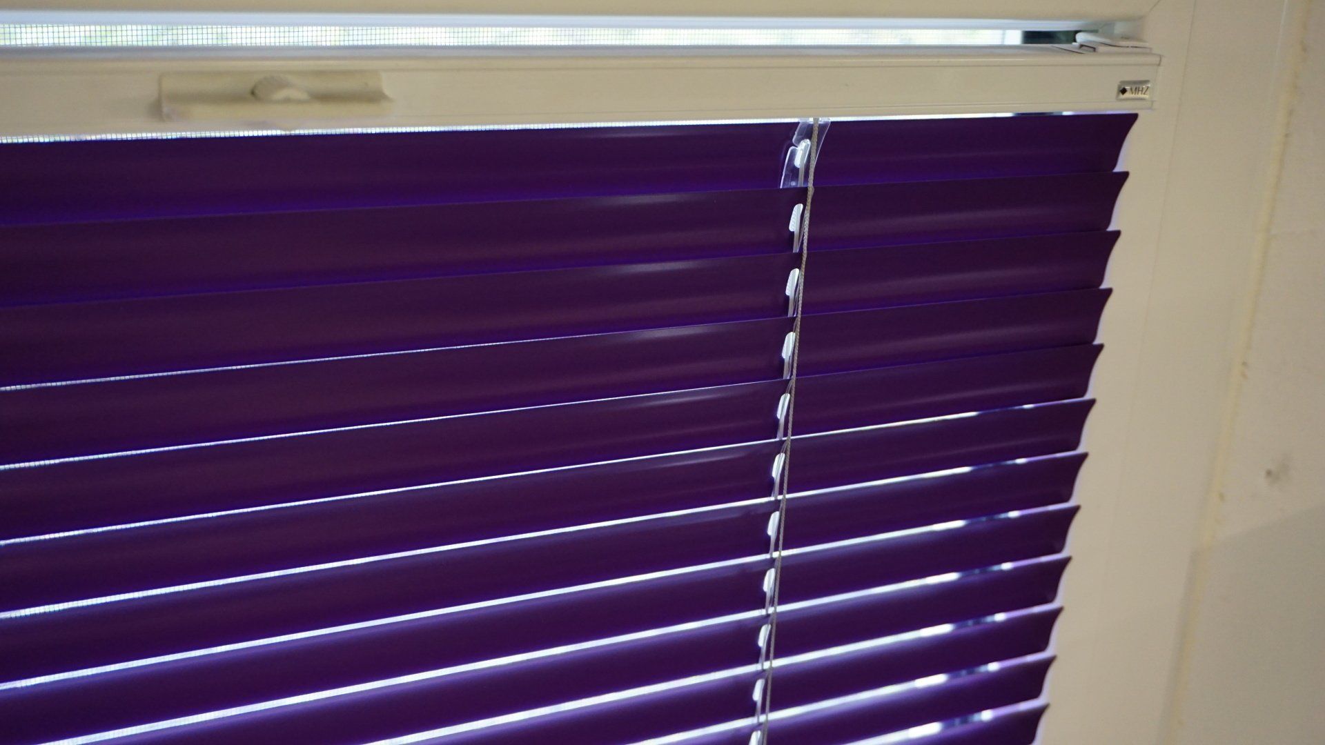 Un gros plan d'un store violet sur une fenêtre