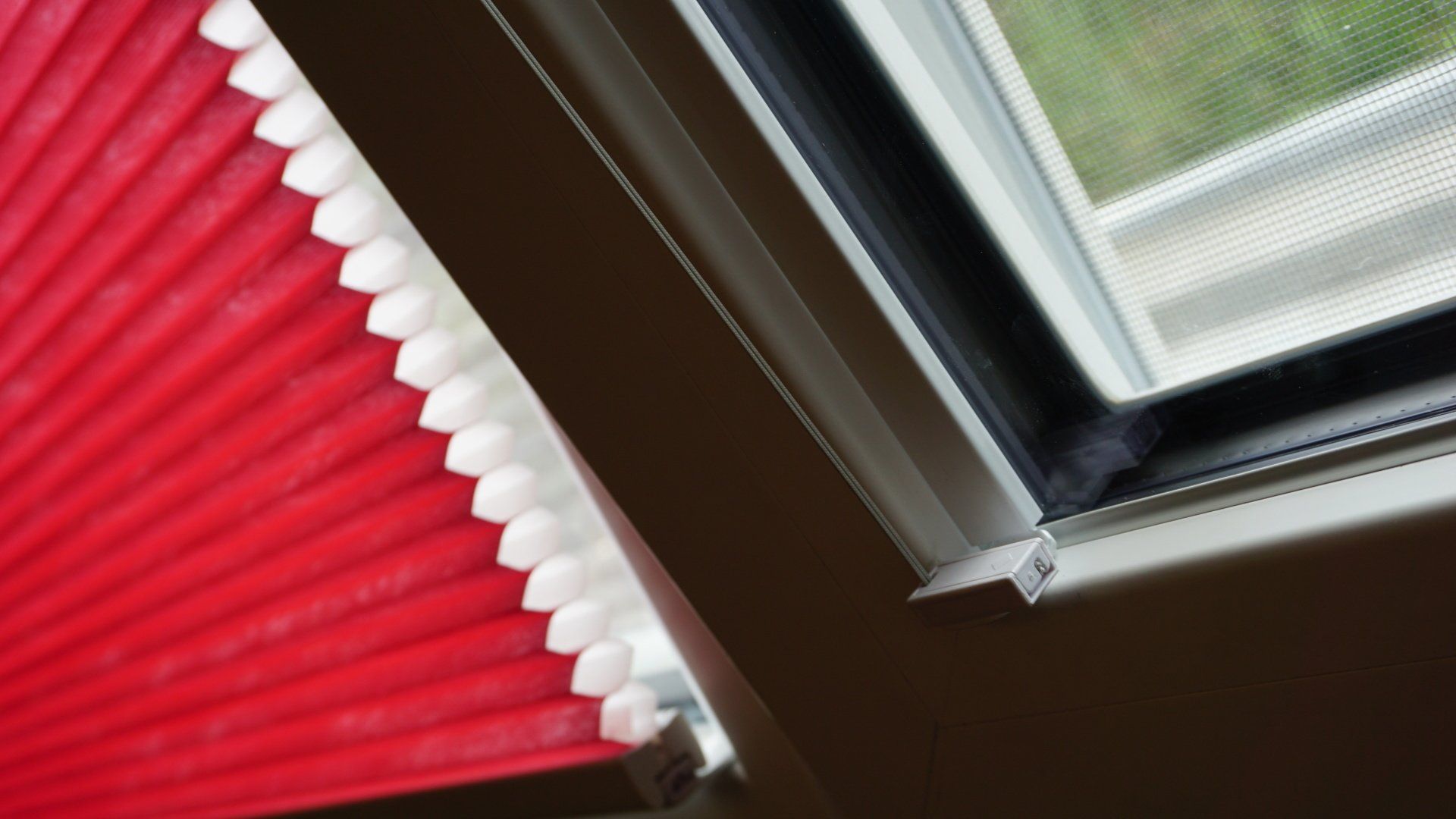 Un gros plan d'une fenêtre avec un store rouge dessus