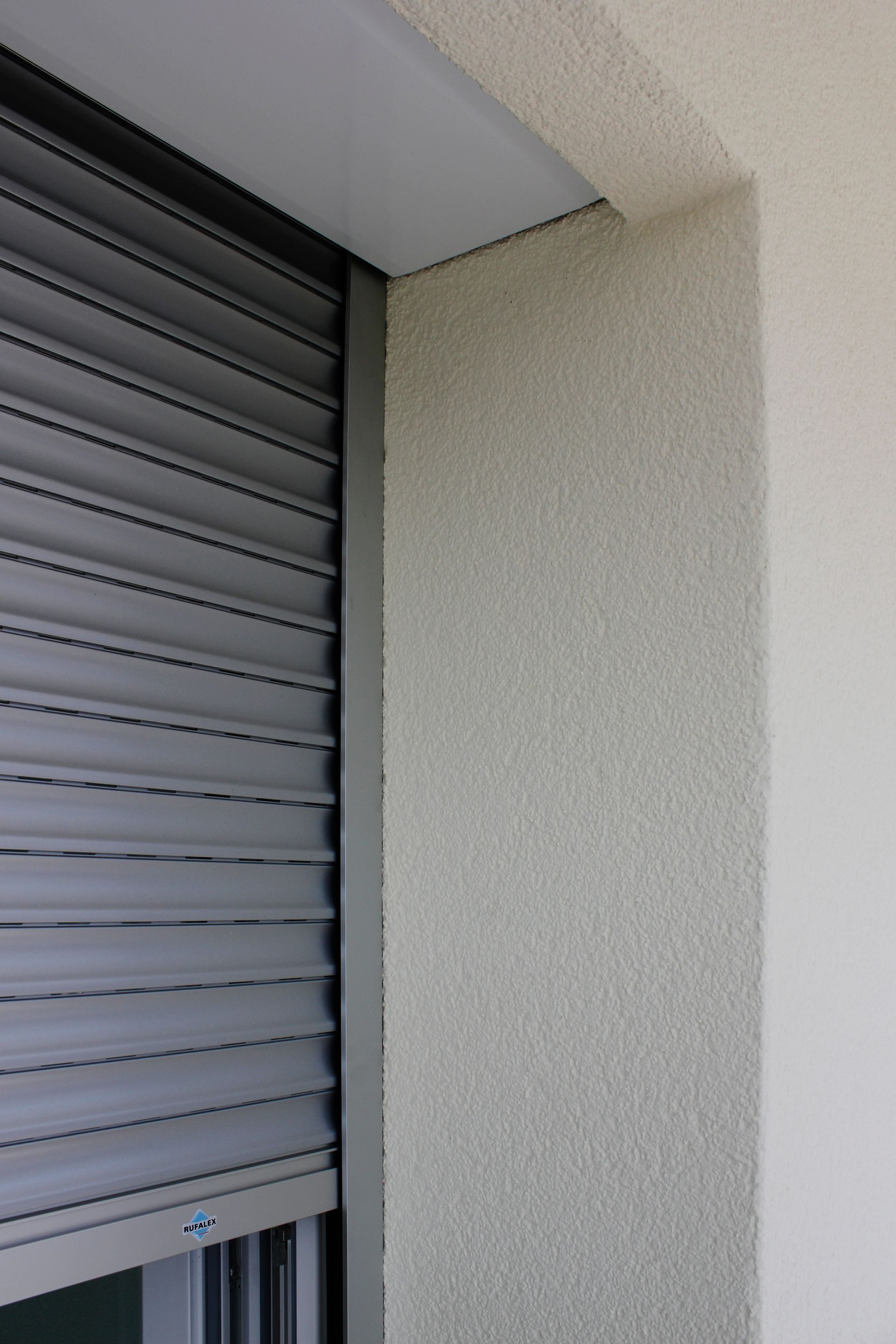 Un gros plan d'une fenêtre avec un volet roulant dessus.