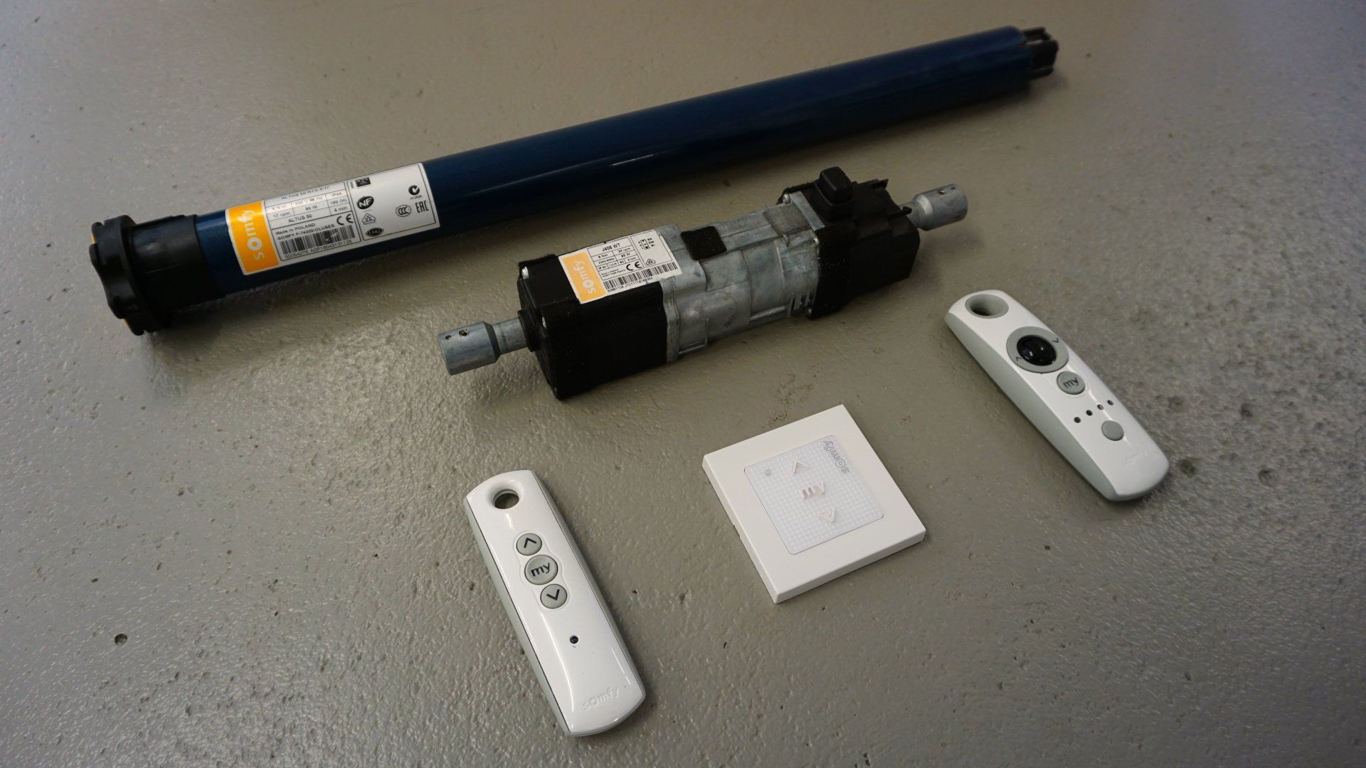 Un moteur et deux télécommandes sont posés sur une table.