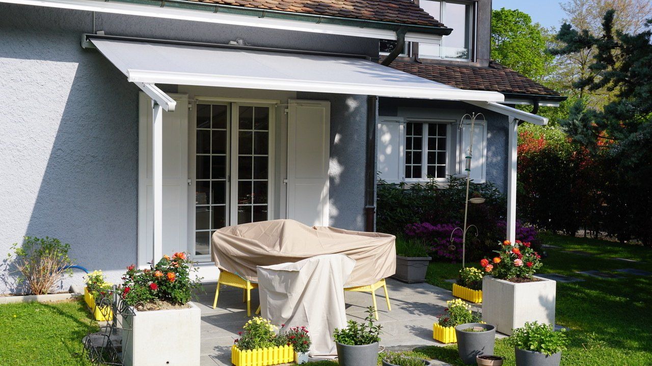 Une maison avec un patio avec une table et des chaises dessus
