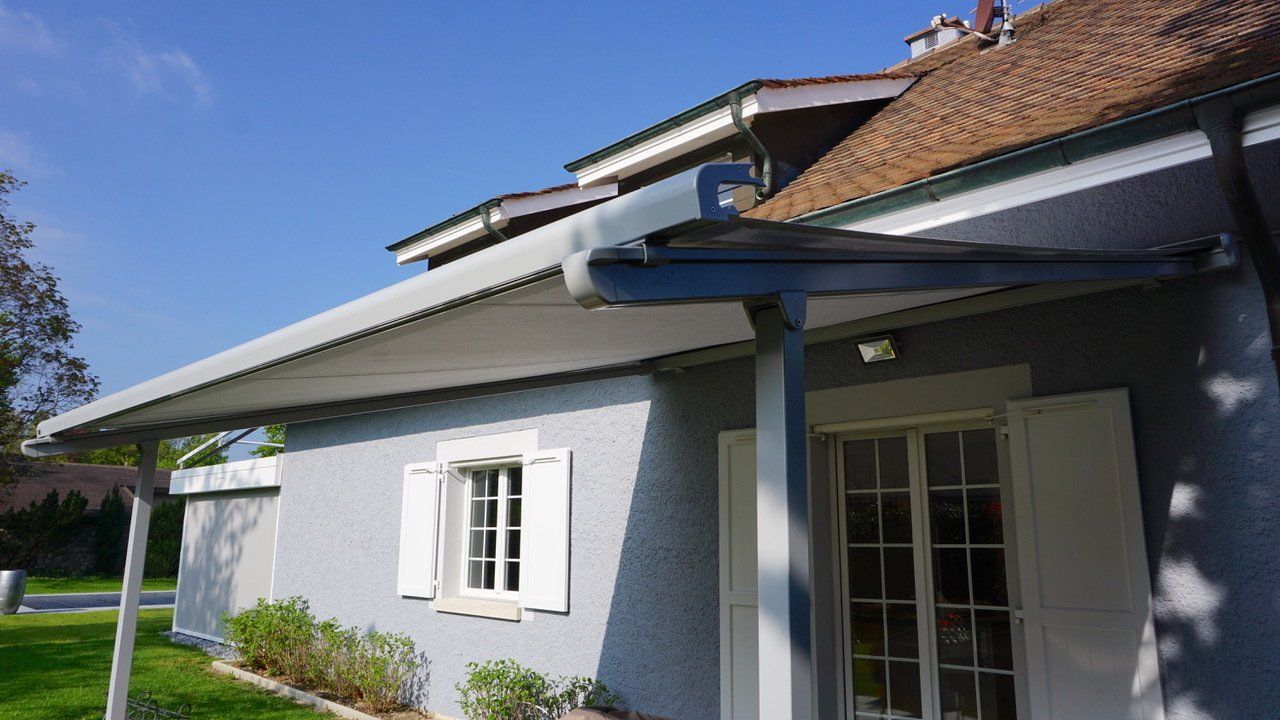 Une maison avec un porche et un auvent sur le toit.