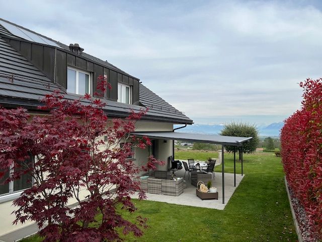 Une maison avec un patio et un auvent devant