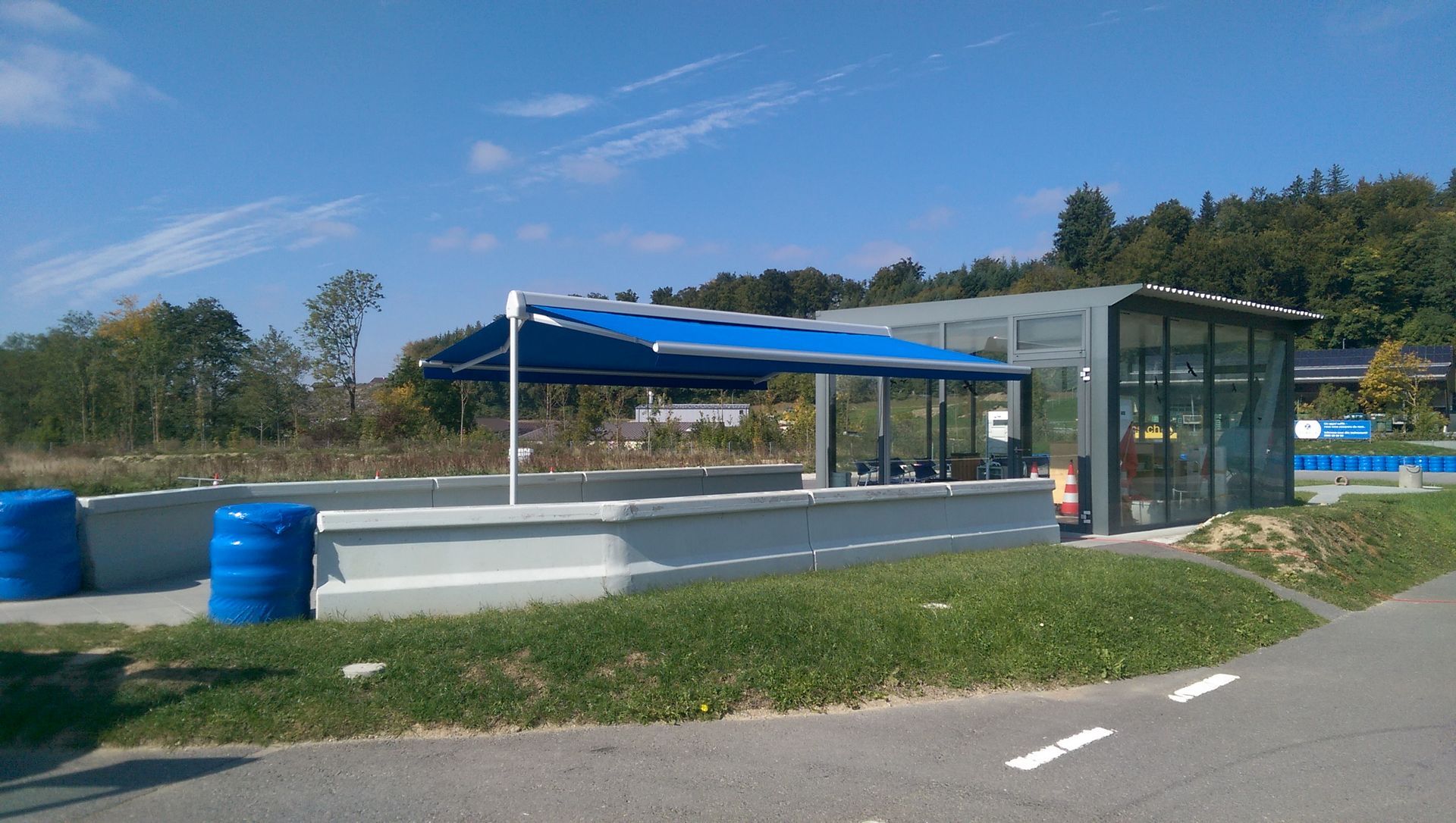 Un parapluie bleu est posé devant un bâtiment.