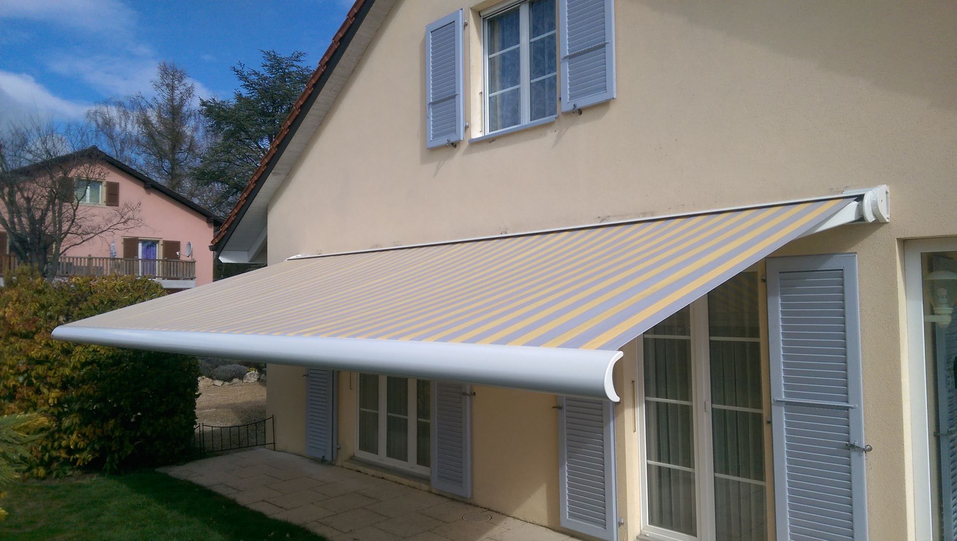 Une maison avec un auvent rayé sur le côté