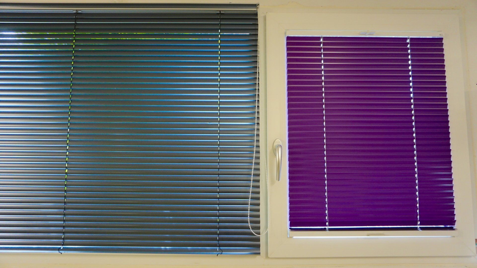 Une fenêtre avec des stores bleus et une fenêtre avec des stores violets