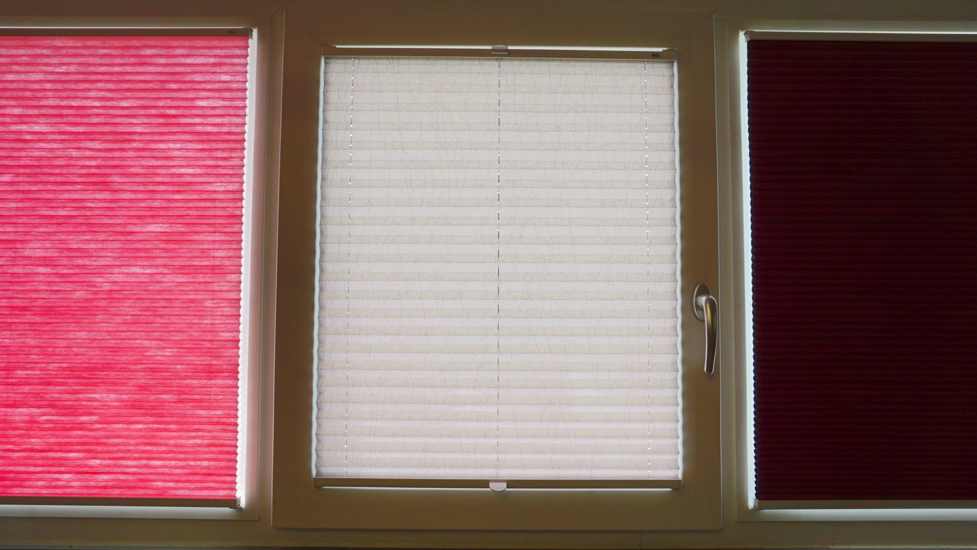 Une fenêtre avec trois types de stores différents