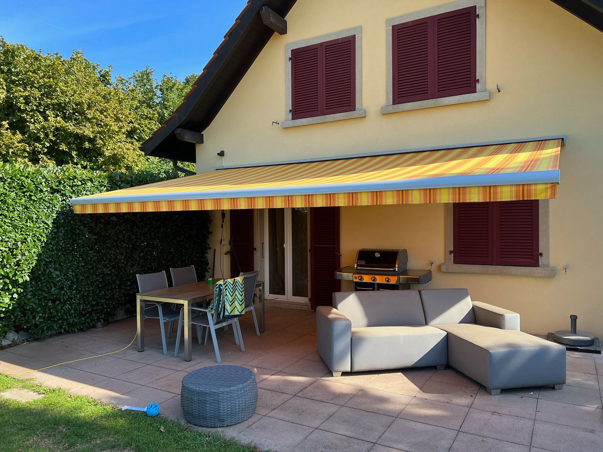 Un patio avec un canapé et une table sous un auvent