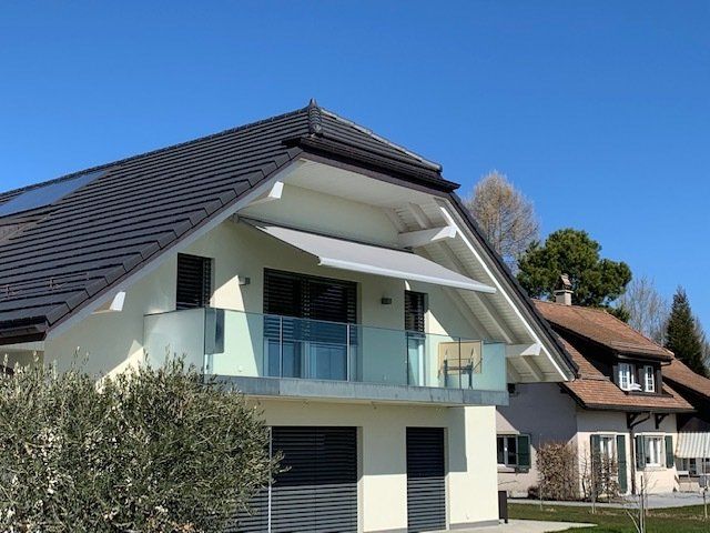 Une maison avec un balcon et un auvent sur le toit
