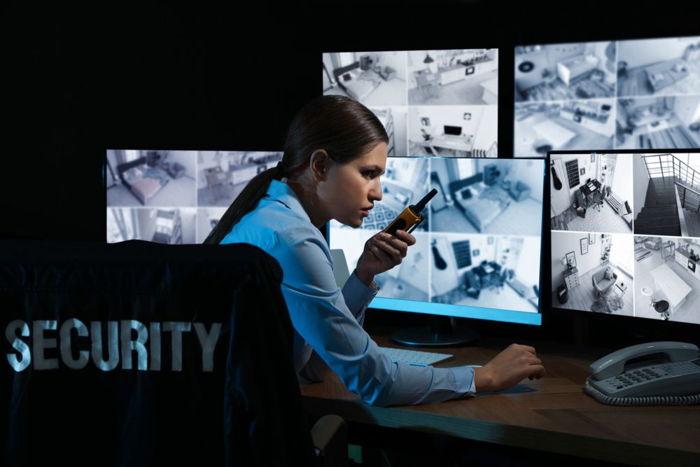 Female Security Guard with Portable Transmitter Monitoring Modern Cctv Cameras at Night - Security Company in Parkes, NSW