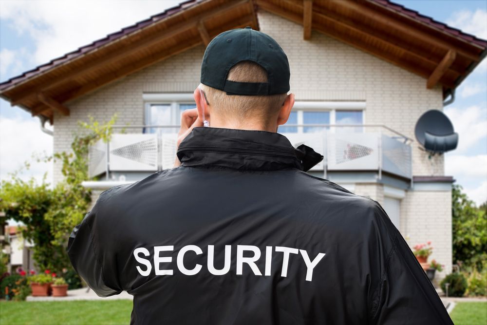 Rear View Of Male Security Guard Standing Outside The House Wearing Black Jacket - Security Company in Gunnedah, NSW
