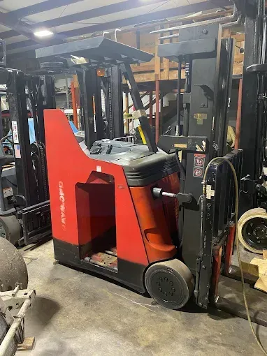 Red and black Raymond reach forklift in a warehouse setting.