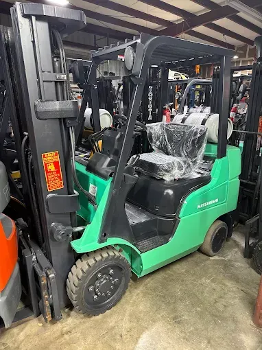 Green Mitsubishi forklift in a warehouse.