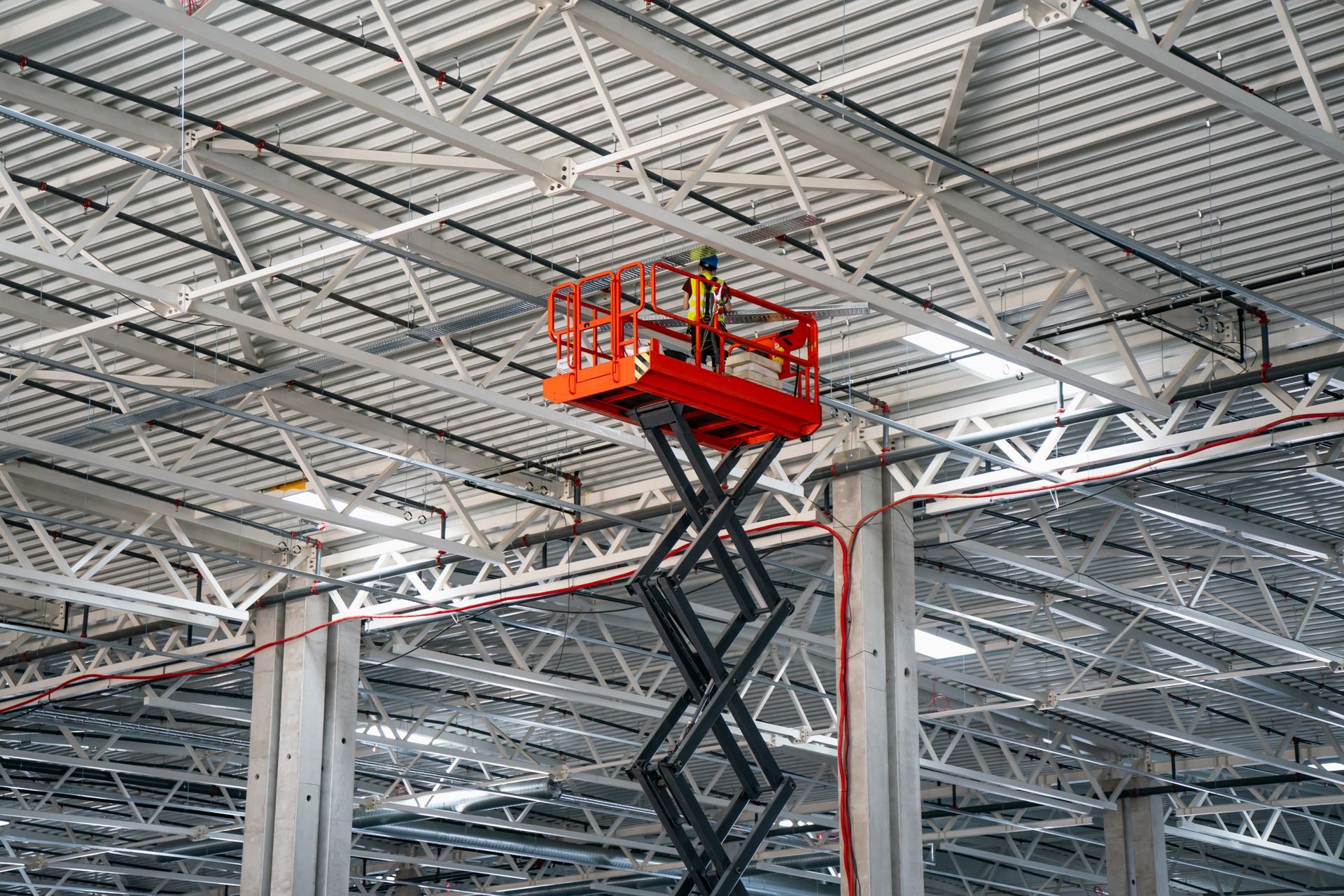 Red forklift carrying cardboard boxes in a warehouse.