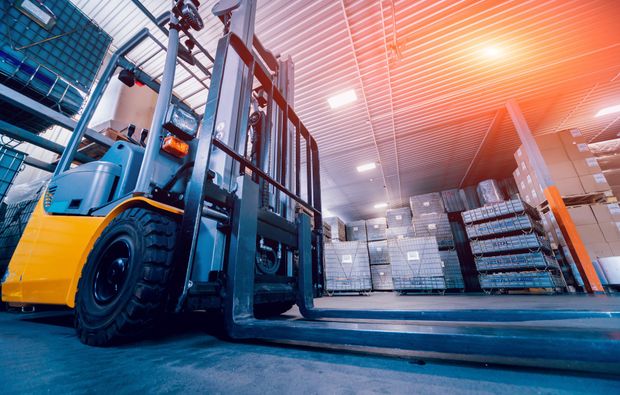 Forklift in a warehouse, moving boxes. Sunlight shines on a busy storage area. Forklift in a warehouse, moving boxes. Sunlight shines on a busy storage area.