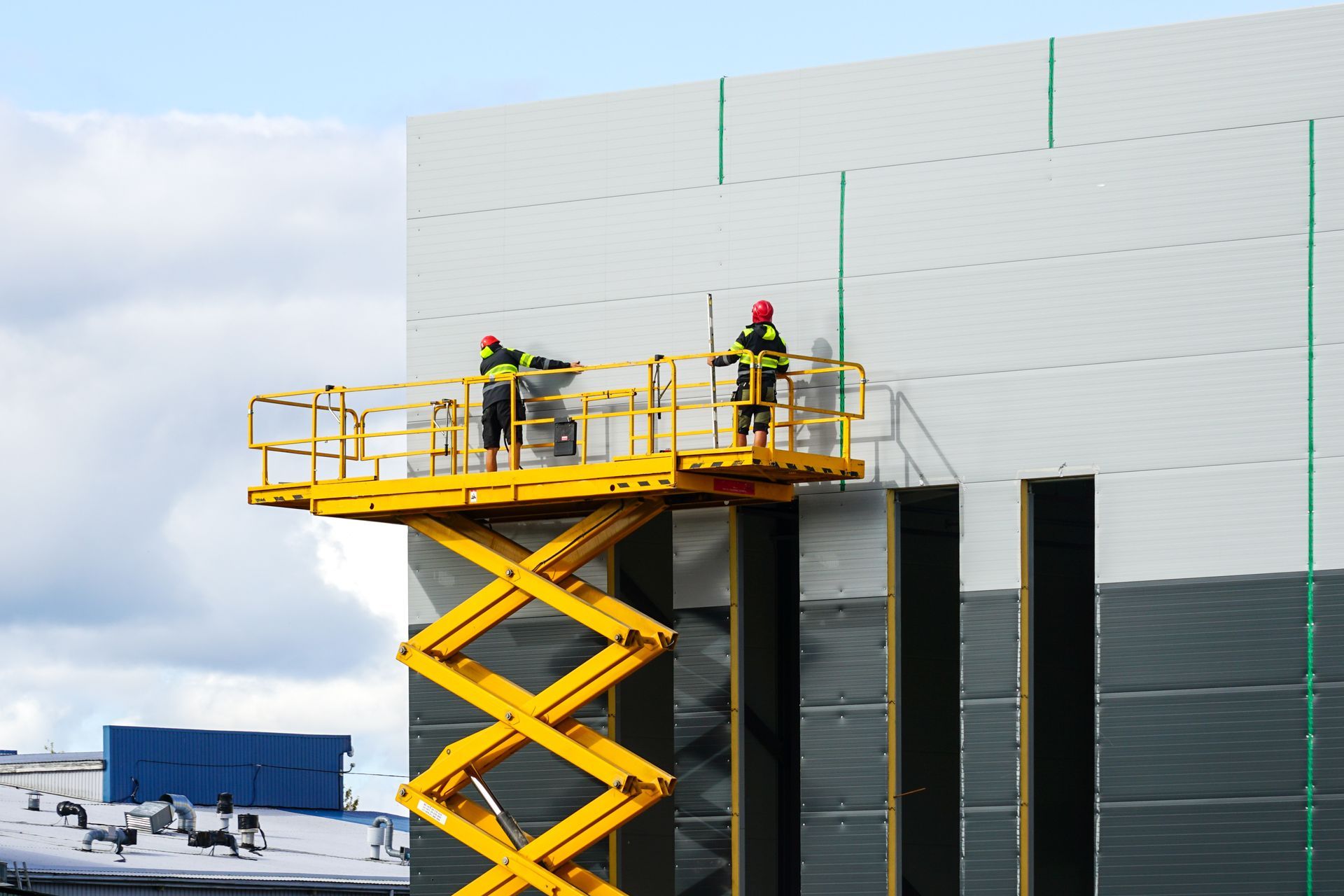 Man operating a forklift, carrying a pallet with a large cardboard box inside a warehouse.