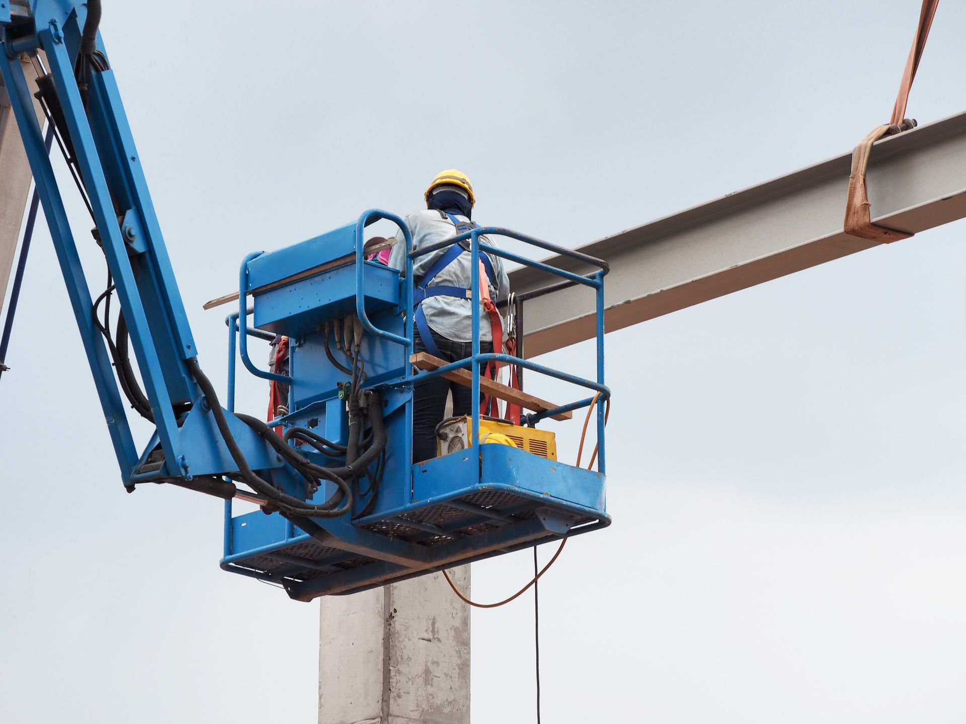 Construction workers working on large-scale telescopic boom lift platforms.