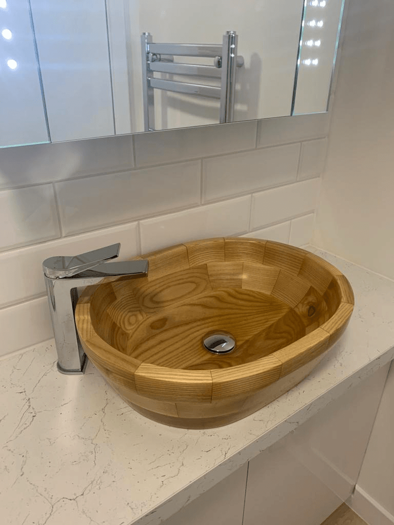 A wooden sink is sitting on top of a counter in a bathroom.