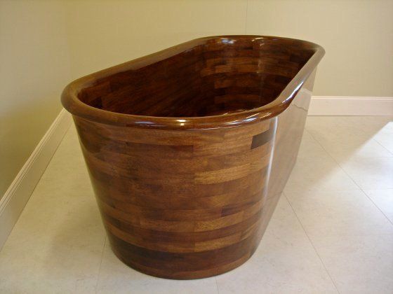A wooden trash can is sitting on a tiled floor