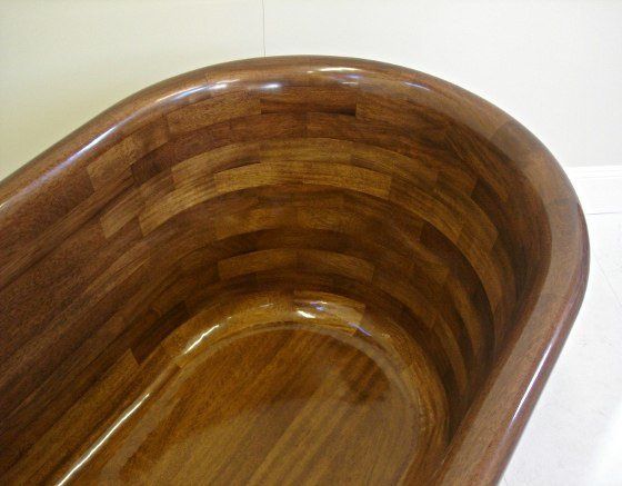 A wooden bathtub is sitting on a white surface