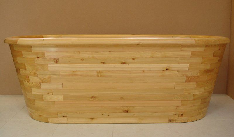 A wooden bathtub is sitting on top of a white table.