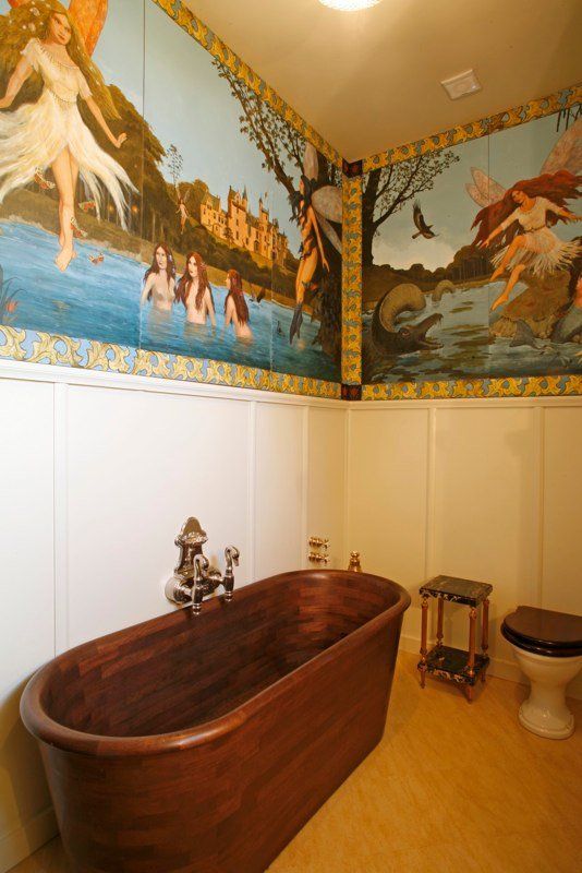 A bathroom with a wooden bathtub and a painting on the wall