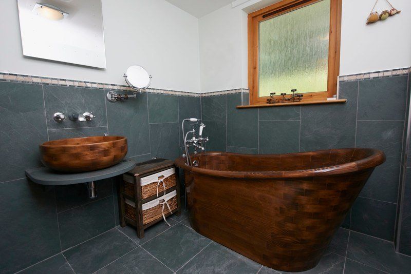 A bathroom with a copper tub and a wooden sink